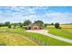 Aerial view of a barn-style home with a long driveway, surrounded by expansive green pastures at 290 Weldon Rd, Fayetteville, GA 30215