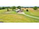 Aerial view of large grassy lawns with fenced fields, barn-style home, and wooded tree line at 290 Weldon Rd, Fayetteville, GA 30215