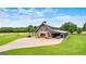 Striking barn-style home with orange doors, a stone archway, and ample parking on brick drive at 290 Weldon Rd, Fayetteville, GA 30215