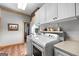 Clean laundry room featuring white appliances, storage, and wood flooring at 290 Weldon Rd, Fayetteville, GA 30215