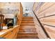 Wooden staircase featuring wood paneling, a black railing, and views of an upstairs loft at 290 Weldon Rd, Fayetteville, GA 30215