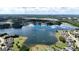 Expansive aerial shot captures the neighborhood and lake, with reflections mirroring the blue sky and scattered clouds at 313 Masters Club Blvd, Hampton, GA 30228
