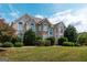 Charming two-story home with arched windows, a well-maintained lawn, and beautiful landscaping at 313 Masters Club Blvd, Hampton, GA 30228