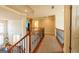 Upstairs hallway overlooking the foyer with wrought iron railings and carpeted floor at 313 Masters Club Blvd, Hampton, GA 30228