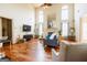 Bright living room with hardwood floors, tall windows, a fireplace, and stylish furnishings at 313 Masters Club Blvd, Hampton, GA 30228