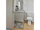 Chic half bathroom with gray vanity, modern fixtures, decorative wall paneling, and patterned rug at 145 Kelmscott Ln, Fayetteville, GA 30214