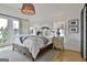 Relaxing bedroom with a rustic wood bed frame, soft linens, and bright natural light from large windows at 145 Kelmscott Ln, Fayetteville, GA 30214