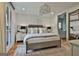 Bright bedroom with a comfortable bed, stylish lighting, and access to a bathroom at 145 Kelmscott Ln, Fayetteville, GA 30214