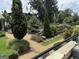 Beautiful community space with landscaped gardens, stone walkways, mature trees, and seating area at 145 Kelmscott Ln, Fayetteville, GA 30214