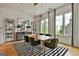 Elegant dining room with wooden table, green velvet chairs, striped rug, and large windows at 145 Kelmscott Ln, Fayetteville, GA 30214
