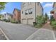 Modern townhouse with a two-car garage, brick facade, and professionally landscaped front yard at 145 Kelmscott Ln, Fayetteville, GA 30214