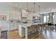 Open kitchen boasts a large island with seating, white cabinets, and modern fixtures at 145 Kelmscott Ln, Fayetteville, GA 30214