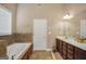 Large bathroom with a jacuzzi tub, double vanity sink, and tiled floors at 204 Carmell Ct, Mcdonough, GA 30252