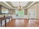 Elegant dining room with hardwood floors, wainscoting, tray ceiling, and abundant natural light at 204 Carmell Ct, Mcdonough, GA 30252
