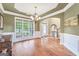Open dining room with hardwood floors, wainscoting, and large window overlooking front yard at 204 Carmell Ct, Mcdonough, GA 30252