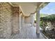 Covered front porch featuring brick columns, wood-look tile, and a welcoming entryway at 204 Carmell Ct, Mcdonough, GA 30252