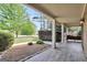 Inviting covered front porch featuring a wood-look floor, classic columns, and landscaped flower beds at 204 Carmell Ct, Mcdonough, GA 30252