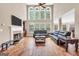 Bright living room features a fireplace, built-in bookshelves, and abundant natural light from tall windows at 204 Carmell Ct, Mcdonough, GA 30252