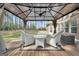 Relaxing outdoor seating area features comfortable chairs, a glass table, and a serene backyard view at 204 Carmell Ct, Mcdonough, GA 30252