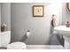 Well-lit powder room featuring a pedestal sink, framed art, and neutral walls at 204 Carmell Ct, Mcdonough, GA 30252