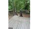 View of backyard deck showing stained wood and wood railing overlooking trees at 140 Clover Valley Dr, Covington, GA 30016