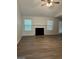 Bright living room with fireplace, wood-look flooring, ceiling fan, and neutral walls at 140 Clover Valley Dr, Covington, GA 30016