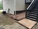 Exterior side yard featuring a patio and staircase leading to the upper deck, surrounded by pine straw at 140 Clover Valley Dr, Covington, GA 30016