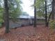 Back exterior of ranch style home surrounded by lush trees and fallen leaves at 1320 Labelle St, Jonesboro, GA 30238