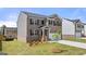 Charming two-story home with a brick and siding exterior, a well-manicured lawn, and a young tree at 604 Whitman Ln # 27, Stockbridge, GA 30281