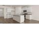 Modern kitchen boasts white cabinets, granite countertops, a center island with sink and stainless steel appliances at 604 Whitman Ln # 27, Stockbridge, GA 30281