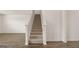 Bright, neutral staircase featuring carpeted steps and white banisters, with hardwood floors at the base at 604 Whitman Ln # 27, Stockbridge, GA 30281