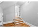 Attic access featuring hardwood steps with white trim, leading to a bright, open space at 203 Shelby Ln, Fayetteville, GA 30215