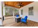 Inviting screened-in porch with wood floors, a ceiling fan, comfortable seating, and views of the wooded backyard at 203 Shelby Ln, Fayetteville, GA 30215