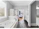 Bathroom with black slate flooring, a soaking tub, and a shower; access into the main bedroom at 203 Shelby Ln, Fayetteville, GA 30215