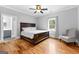 Bedroom boasts hardwood floors, a ceiling fan, and an open doorway to a walk-in closet, creating comfort and functionality at 203 Shelby Ln, Fayetteville, GA 30215