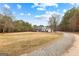 Stately home featuring a columned front porch, complemented by a long, gravel driveway and surrounding mature trees at 203 Shelby Ln, Fayetteville, GA 30215