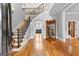 Grand foyer features hardwood floors, a staircase with iron railings, and elegant decor with views to the living room at 203 Shelby Ln, Fayetteville, GA 30215
