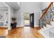 Elegant foyer featuring hardwood floors, a staircase with iron railings, and an arched entryway with views of the front lawn at 203 Shelby Ln, Fayetteville, GA 30215