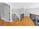 Upstairs hallway featuring hardwood floors and wood and iron railing between rooms at 203 Shelby Ln, Fayetteville, GA 30215