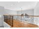 Upstairs hallway with hardwood floors, wood and iron railing, and a view of the backyard pool at 203 Shelby Ln, Fayetteville, GA 30215