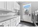 Bright laundry room features washer, dryer, white cabinets, granite counters, and tile floors at 203 Shelby Ln, Fayetteville, GA 30215