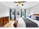 Main bedroom featuring hardwood floors, a ceiling fan, and two windows with blue drapes at 203 Shelby Ln, Fayetteville, GA 30215