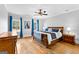 Main bedroom featuring hardwood floors, a ceiling fan, and two windows with blue drapes at 203 Shelby Ln, Fayetteville, GA 30215