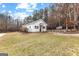 Charming white outbuilding with blue shutters, nestled in a serene, wooded landscape at 203 Shelby Ln, Fayetteville, GA 30215