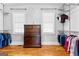 Spacious walk-in closet with built-in shelving, hardwood floors, and a wooden dresser between two windows at 203 Shelby Ln, Fayetteville, GA 30215