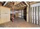 Unfinished basement displays exposed ceiling, wooden beams, and ample space for storage or renovation at 5552 Smithfield Rd, Bowdon, GA 30108