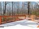 Snow-covered wooden deck offers a serene view of the surrounding bare trees in a tranquil setting at 5552 Smithfield Rd, Bowdon, GA 30108