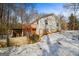 Exterior of a quaint home with a wooden deck, snowy ground and surrounded by tall trees at 5552 Smithfield Rd, Bowdon, GA 30108