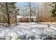 Charming single-story home with a cozy front porch and snowy front yard surrounded by trees at 5552 Smithfield Rd, Bowdon, GA 30108
