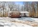 Inviting single-story home featuring a quaint front porch and lush trees in the winter at 5552 Smithfield Rd, Bowdon, GA 30108
